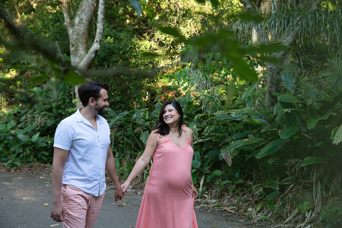 Foto de casal em ensaio gestante no Rio, rodeados pela vegetação próxima à Praia Vermelha.
