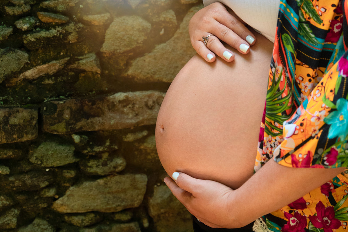 Detalhe da barriga em ensaio de gestante no Jardim Botânico do Rio de Janeiro.