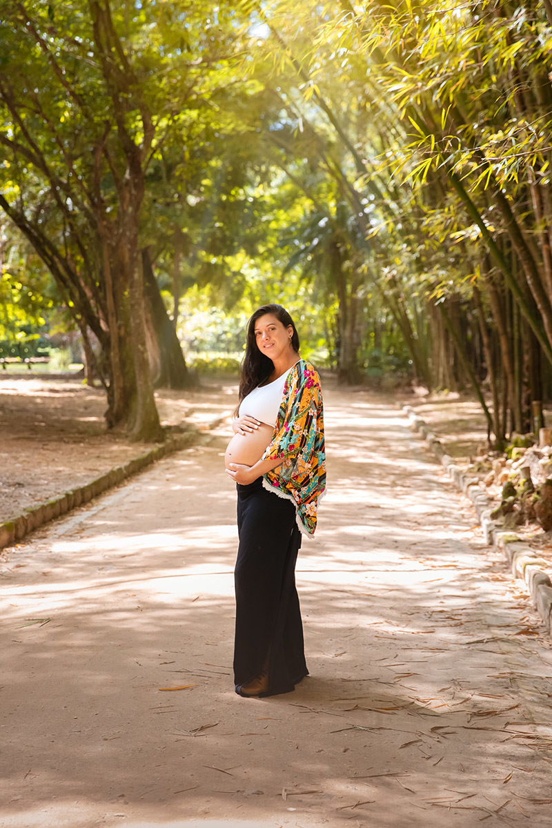 Foto de gestante caminhando em alameda do Jardim Botânico do Rio de Janeiro.