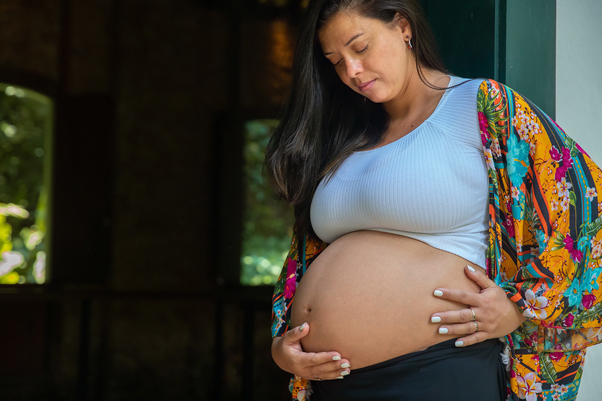 Ensaio de gestante no Jardim Botânico, registrando a emoção da espera.