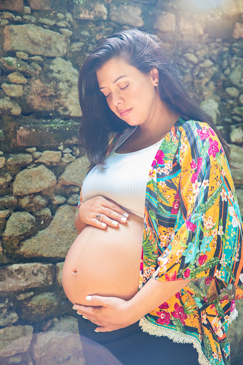 Gestante acariciando a barriga em ensaio fotográfico no Jardim Botânico do Rio de Janeiro.