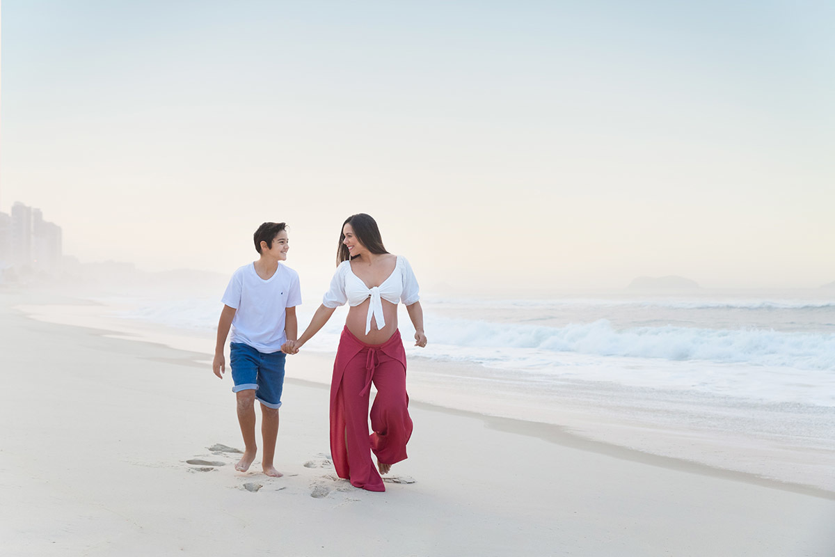 Ensaio de gestante na praia: Silvia, e Matheus andando na areia, no Rio de Janeiro.