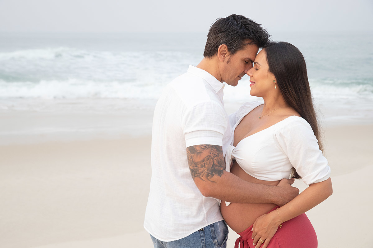 Ensaio de gestante na praia: Silvia, Sanderson se olhando, no Rio de Janeiro.