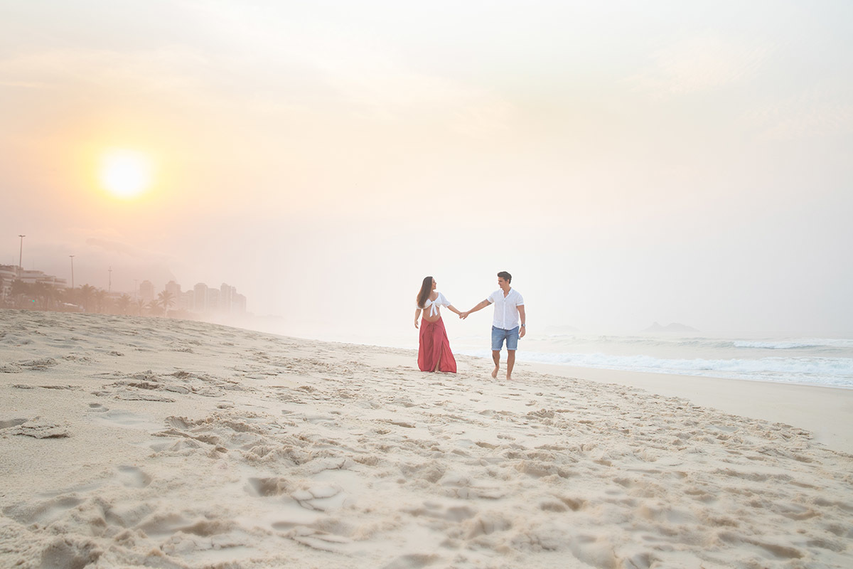 Ensaio de gestante na praia: Silvia, Sanderson andando na areia, no Rio de Janeiro.
