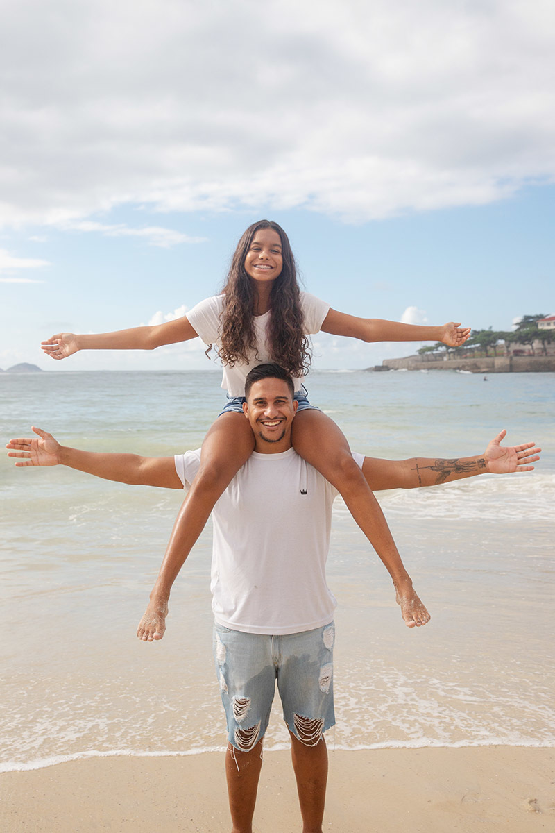 Ensaio família na praia de Copacabana:  irmãos brincando na areia no Rio de Janeiro.