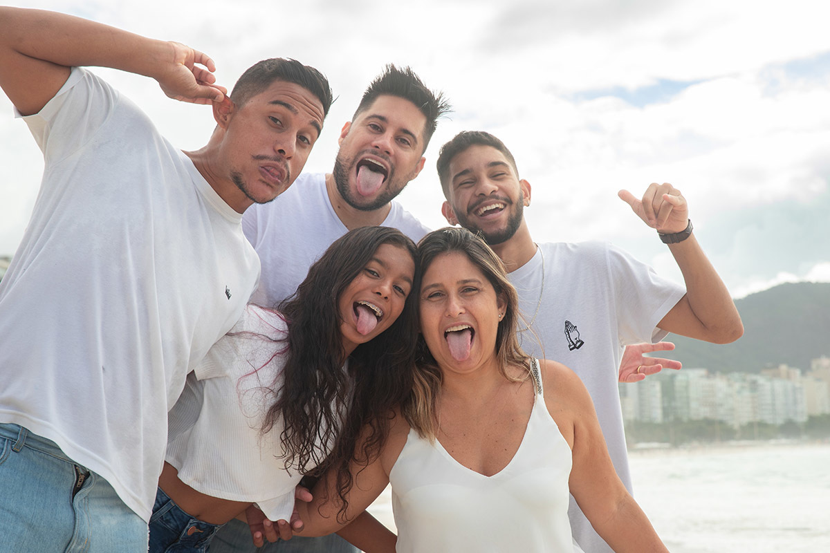 Ensaio família na praia de Copacabana: Nehylza com a família fazendo careta no Rio de Janeiro.