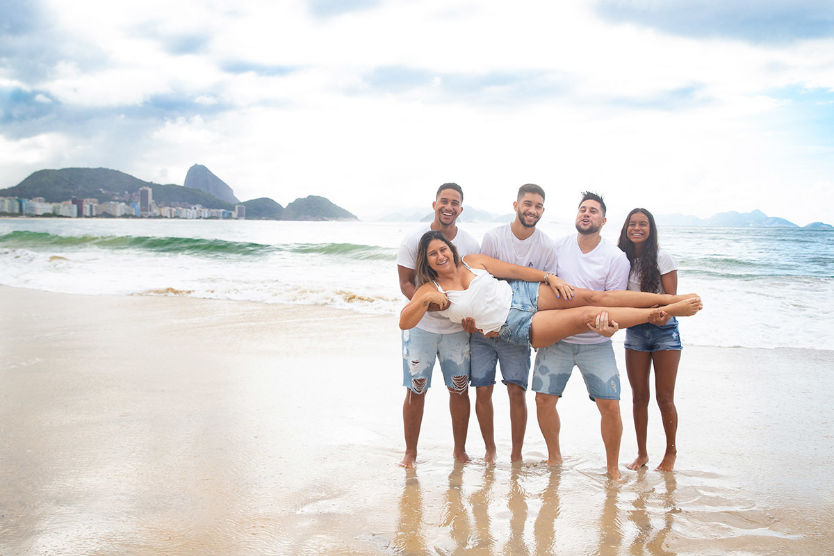 Ensaio família na praia de Copacabana: Nehylza no colo dos filhos no Rio de Janeiro.