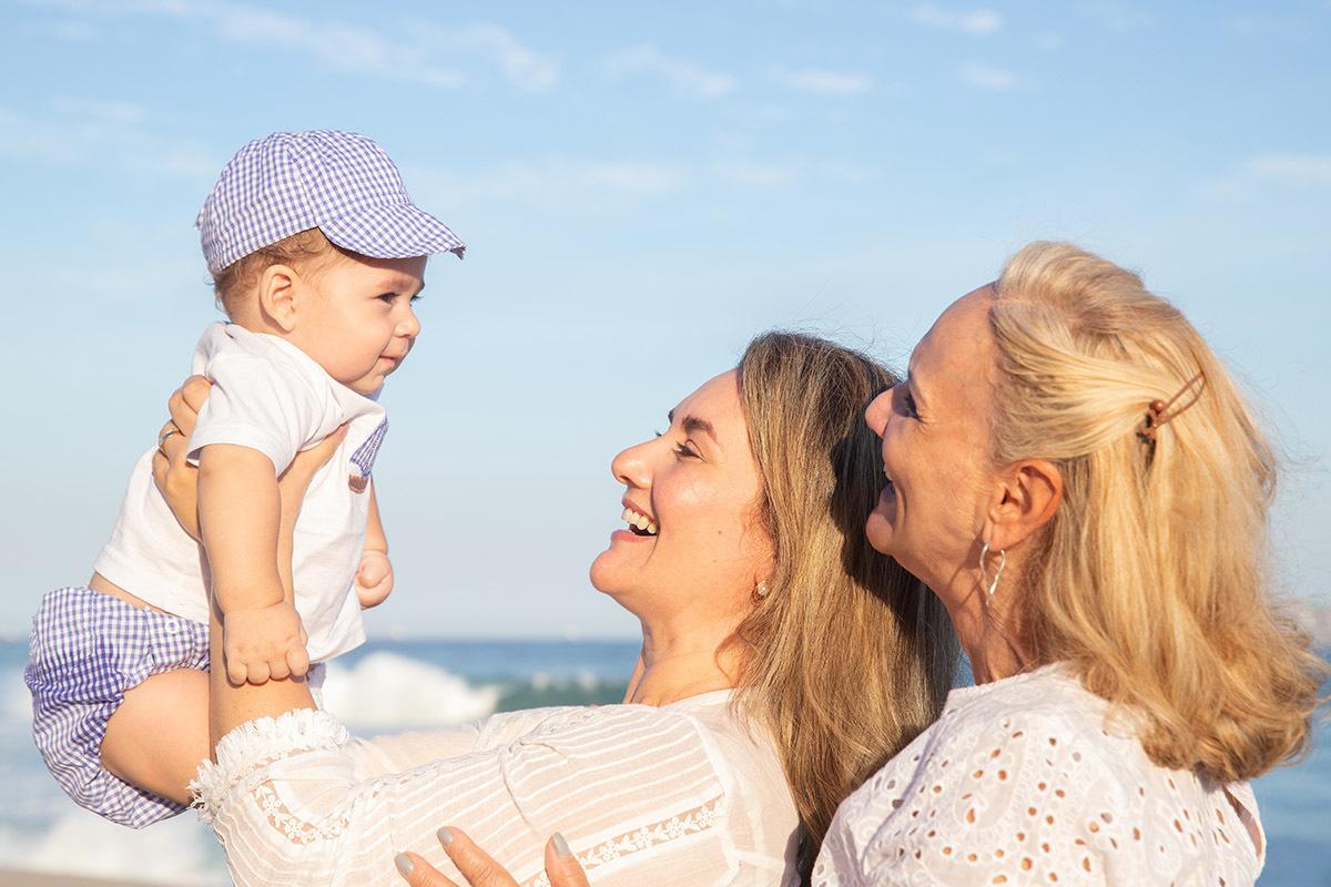 Ensaio bebê na praia: LU e vovó brincando com o Vitor no Rio de Janeiro.