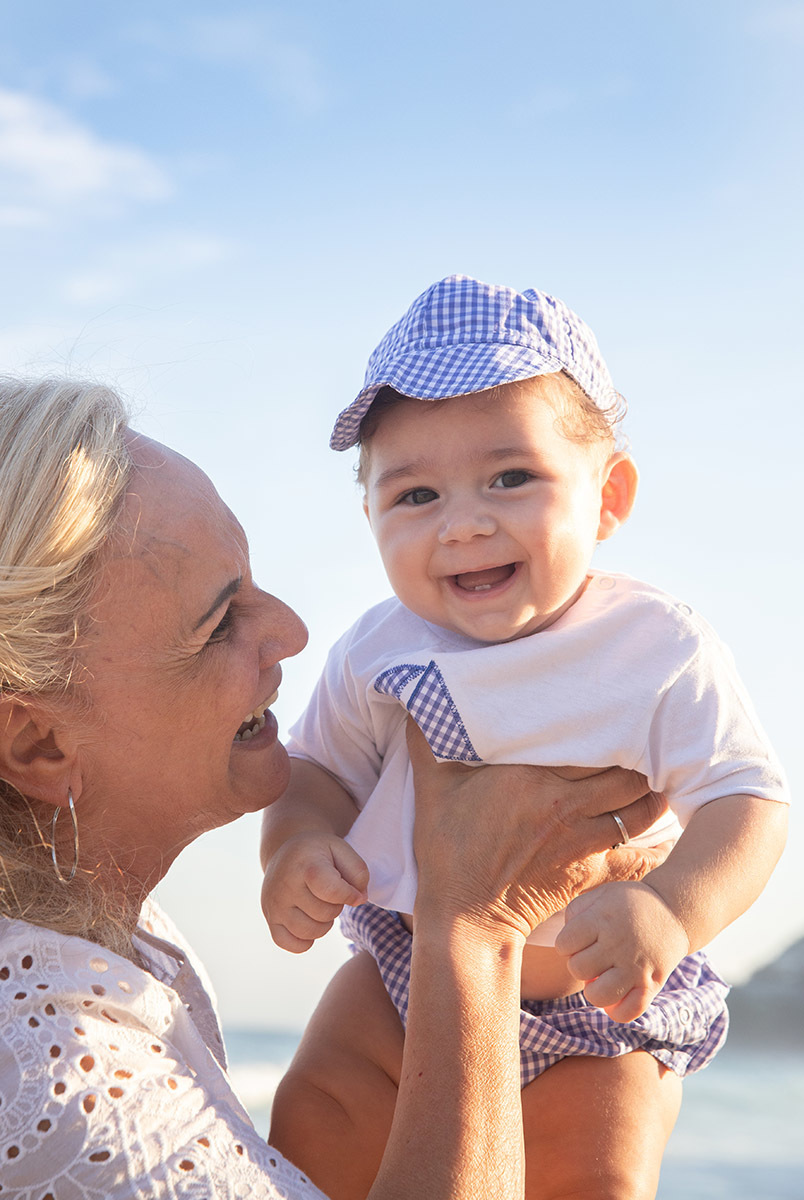 Ensaio bebê na praia: Vitor no colo da vovó no Rio de Janeiro.