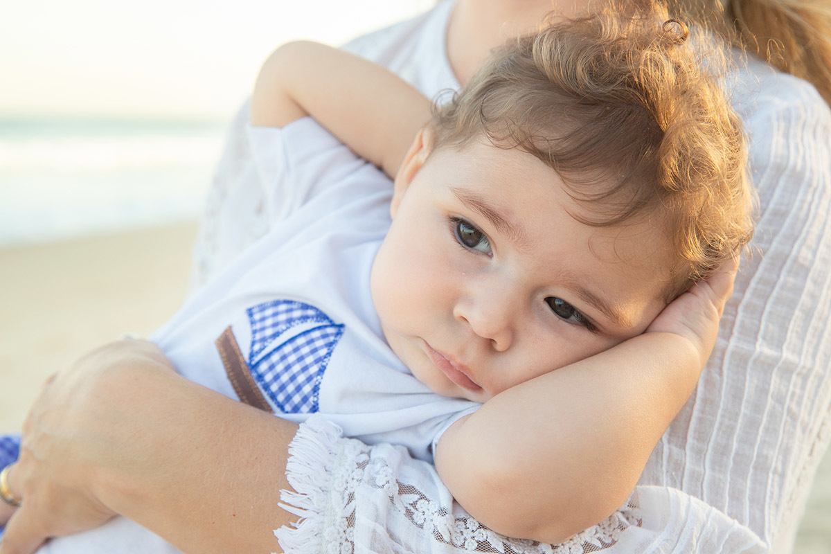 Ensaio bebê na praia: Vitor no colo da Lu no Rio de Janeiro.