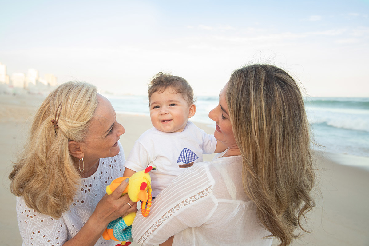 Ensaio bebê na praia: LU e vovó brincando com o Vitor no Rio de Janeiro.