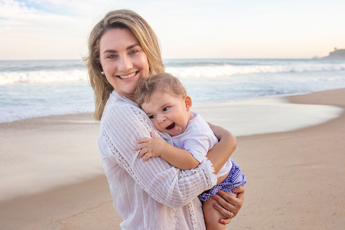 Ensaio bebê na praia: Vitor no colo da Lu no Rio de Janeiro.