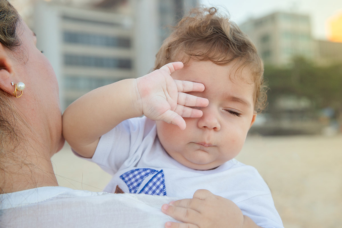 Ensaio bebê na praia: Vitor no colo da Lu no Rio de Janeiro.