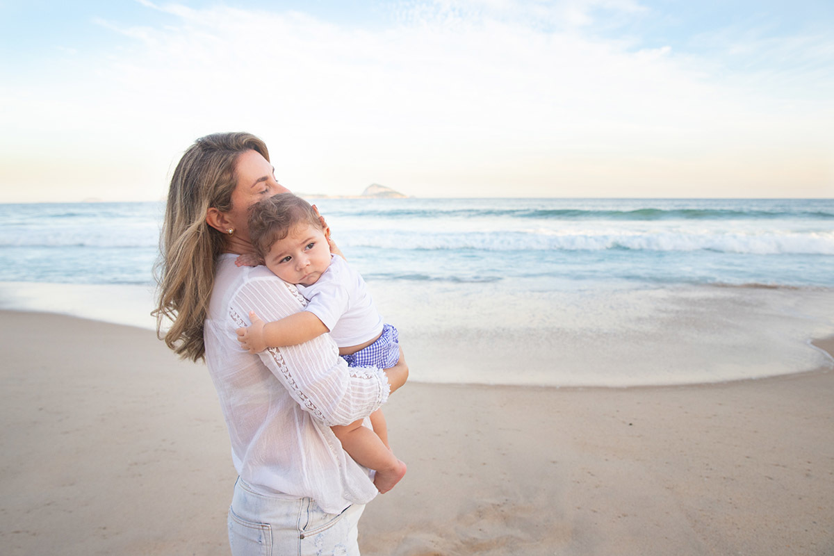 Ensaio bebê na praia: Vitor no colo da Lu no Rio de Janeiro.