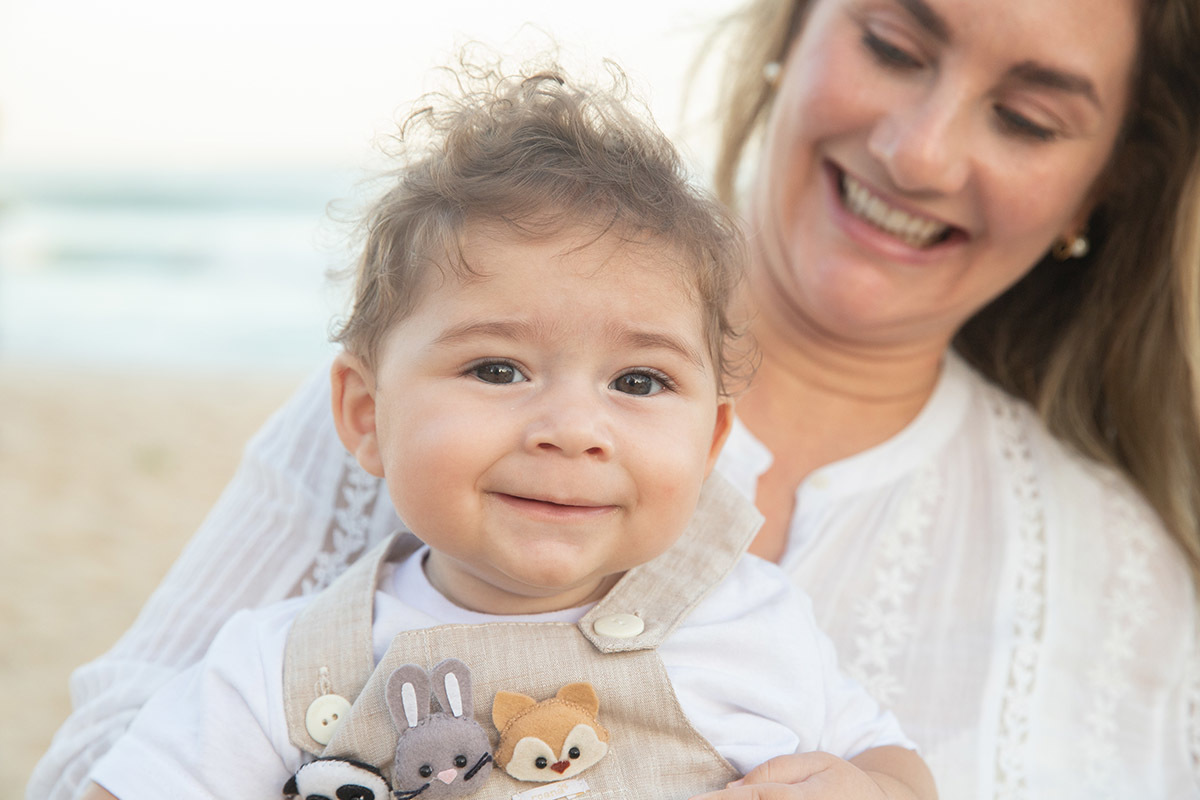 Ensaio bebê na praia: Vitor no colo da Lu no Rio de Janeiro.