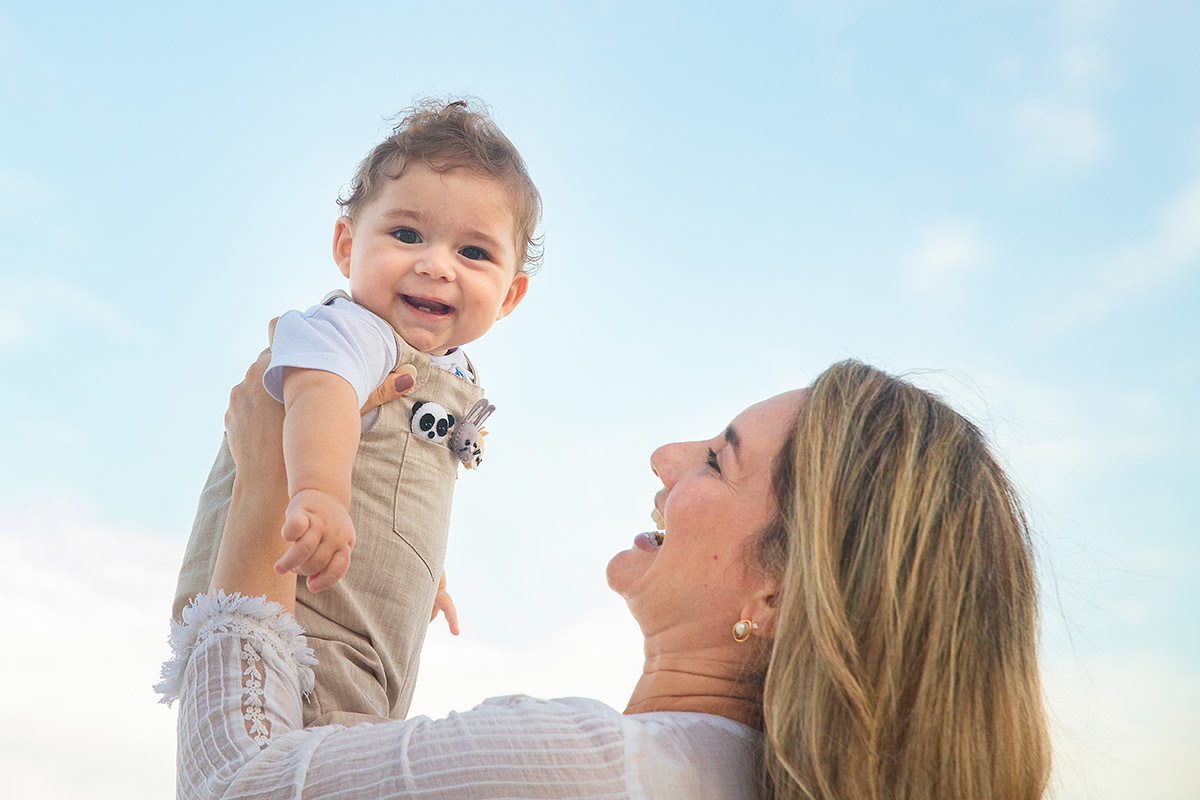 Ensaio bebê na praia: Vitor no colo da Lu no Rio de Janeiro.