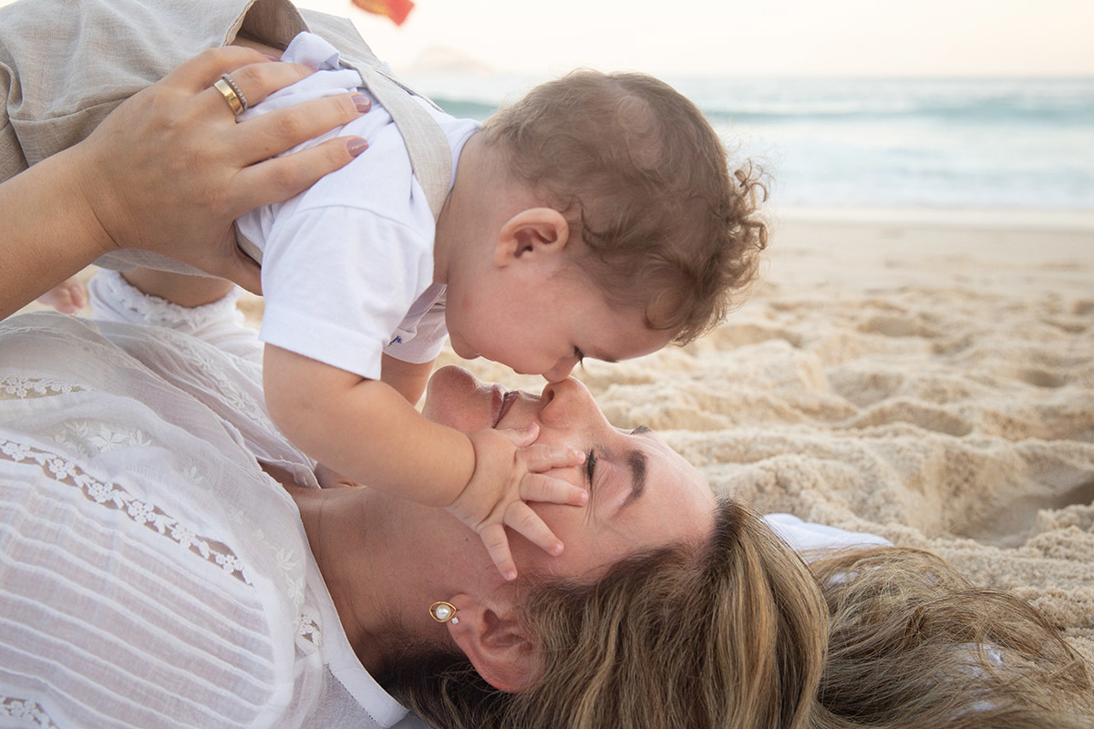 Ensaio bebê na praia: Vitor deitado com a Lu no Rio de Janeiro.