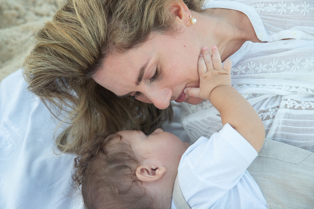 Ensaio bebê na praia: Vitor deitado com a Lu no Rio de Janeiro.