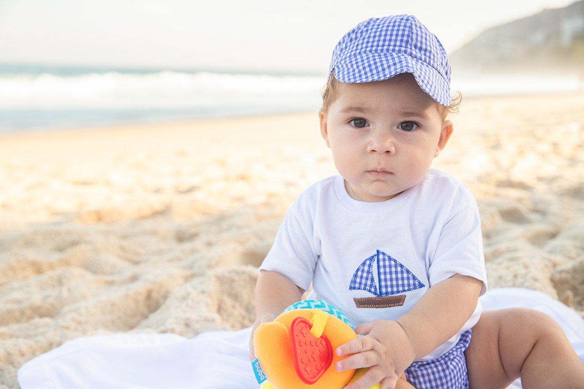 Ensaio bebê na praia: Vitor brincando na areia no Rio de Janeiro.