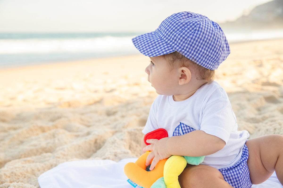 Ensaio bebê na praia: Vitor olhando para o mar no Rio de Janeiro.