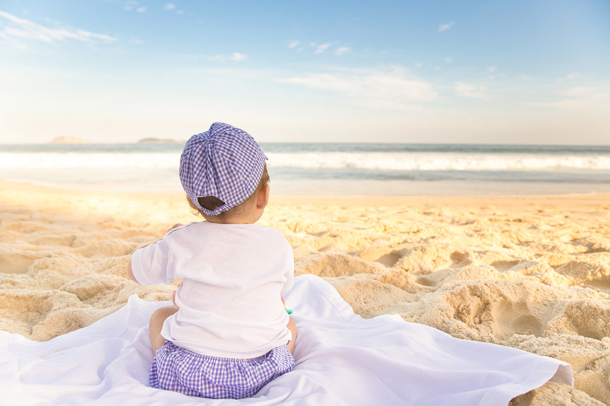 Ensaio bebê na praia: Vitor de costas na areia o Rio de Janeiro.