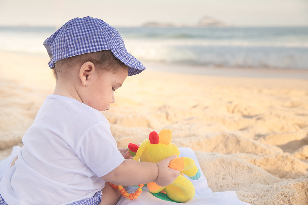 Ensaio bebê na praia: Vitor brincando na areia no Rio de Janeiro.