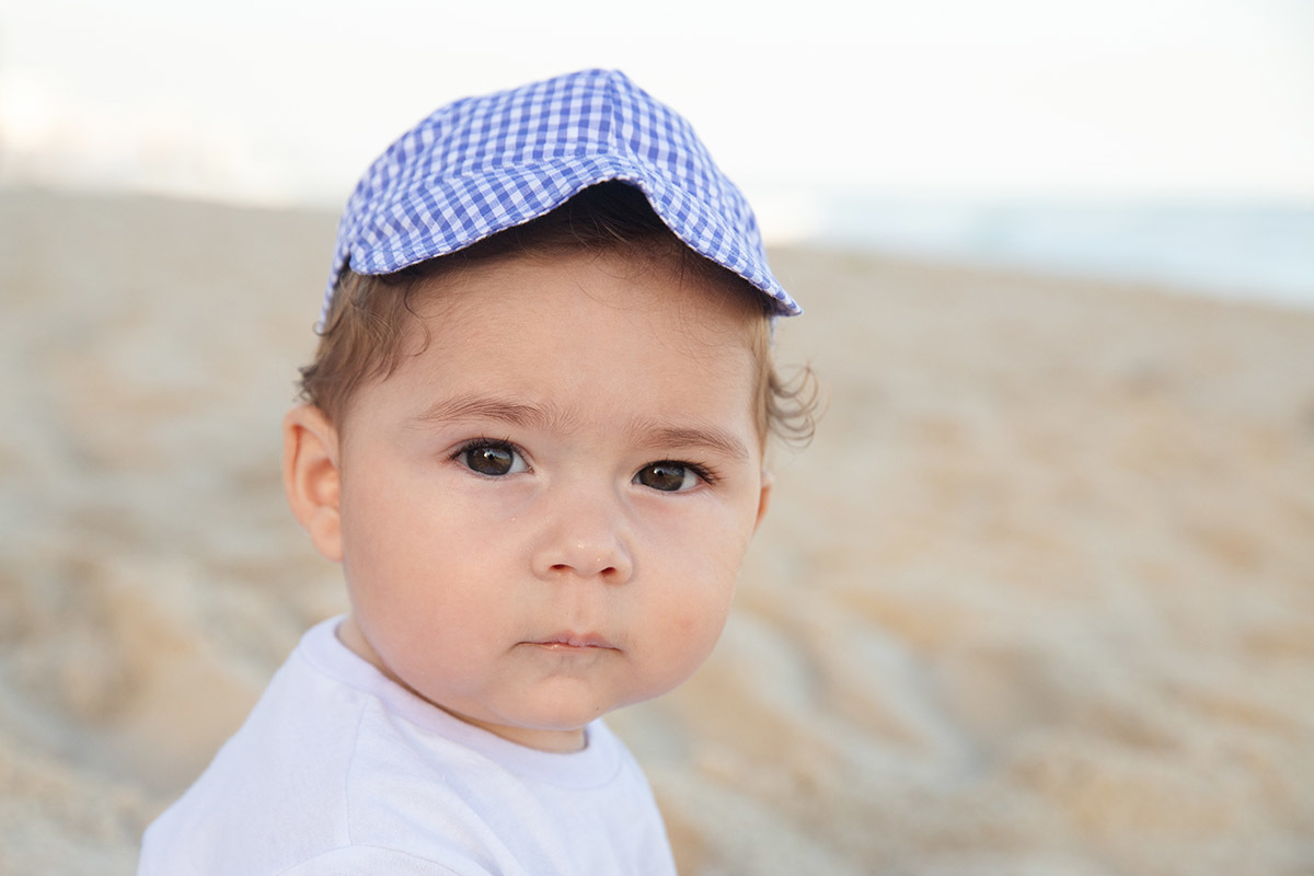 Ensaio bebê na praia: Vitor na areia no Rio de Janeiro.