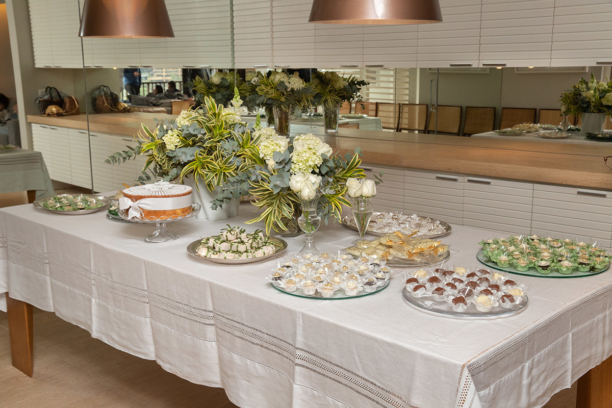 Mesa de doces com arranjo de flores brancas - batizado do Eduardo - Rio de Janeiro.