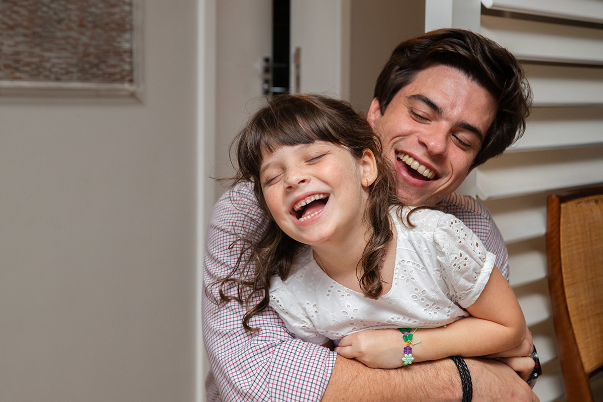 tio abraçando a sobrinha dando gargalhada - batizado do Eduardo - Rio de Janeiro - RJ.