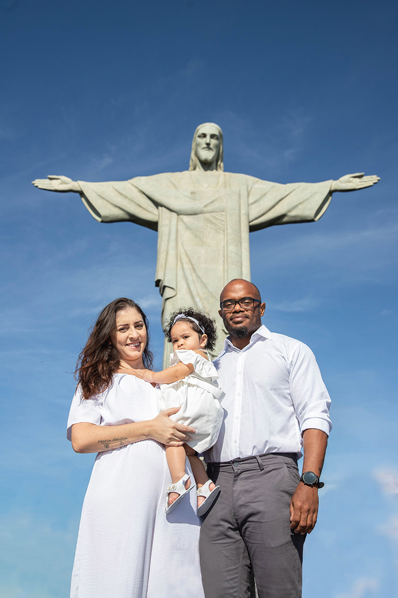 Batizado da Maria Ceília: Larissa e Estevam em frente ao Cristo Redentor no Corcovado, no Rio de Janeiro.