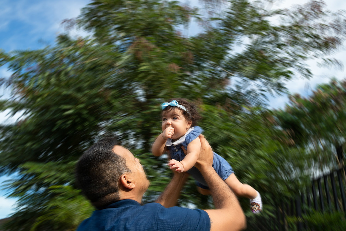 Ensaio de bebê: Ester com o pai no alto no jardim no Rio de Janeiro.