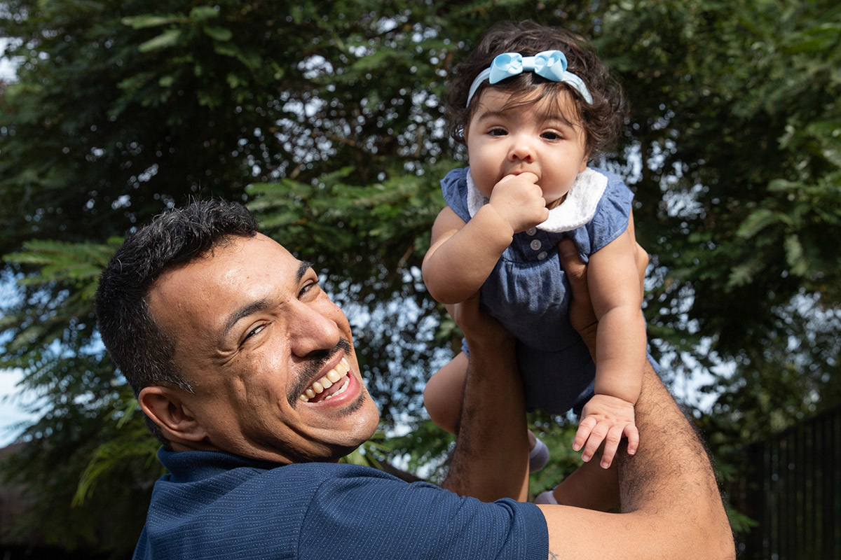 Ensaio de bebê: Ester com o pai no alto no jardim no Rio de Janeiro.