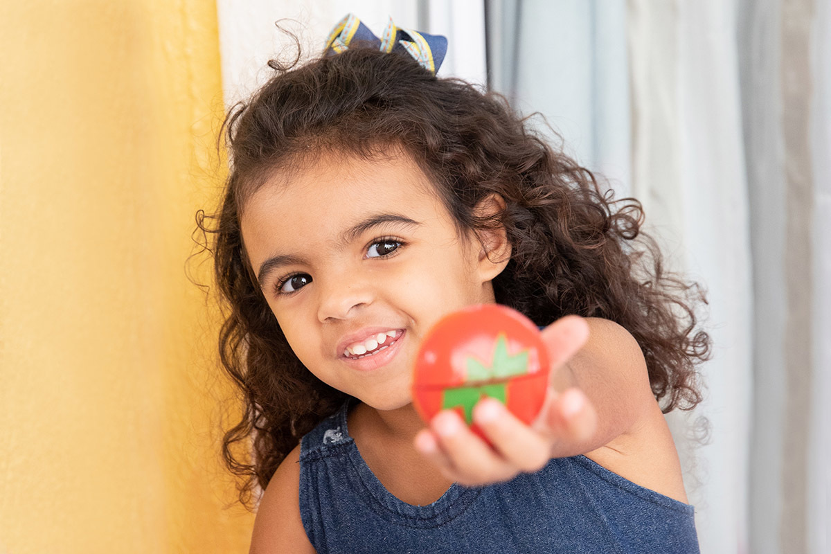 Ensaio de bebê: irmã da Ester mostrando brinquedo no Rio de Janeiro.