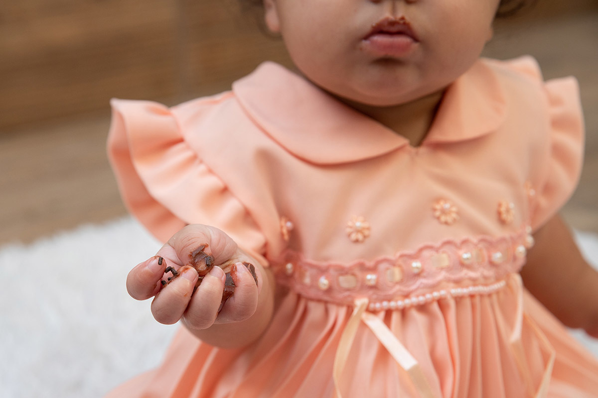 Ensaio de bebê: Ester com a mão suja de bolo no Rio de Janeiro.