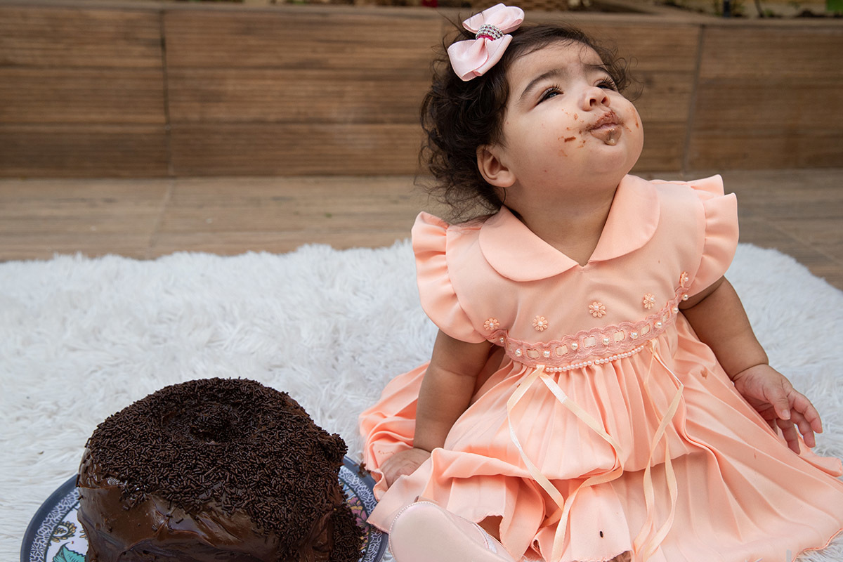 Ensaio de bebê: Ester com a boca suja de bolo no Rio de Janeiro.
