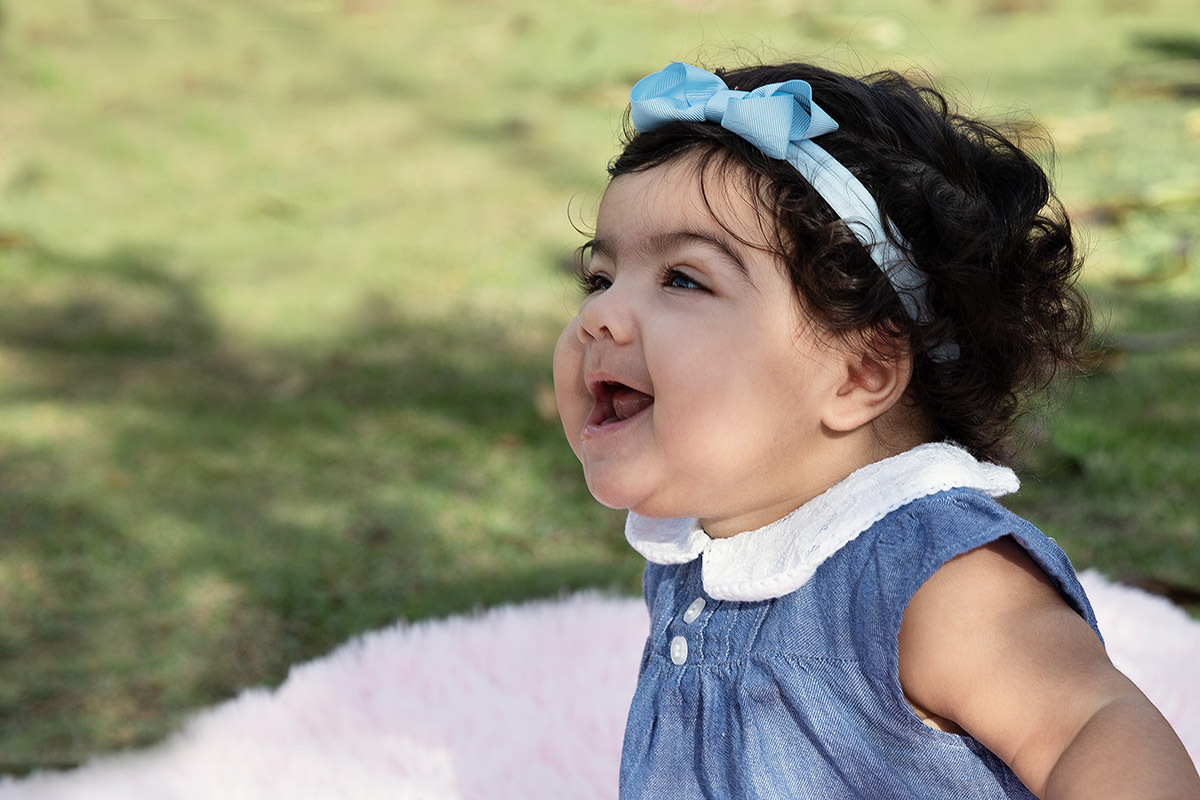 Ensaio de bebê: Ester sorrindo no jardim no Rio de Janeiro.