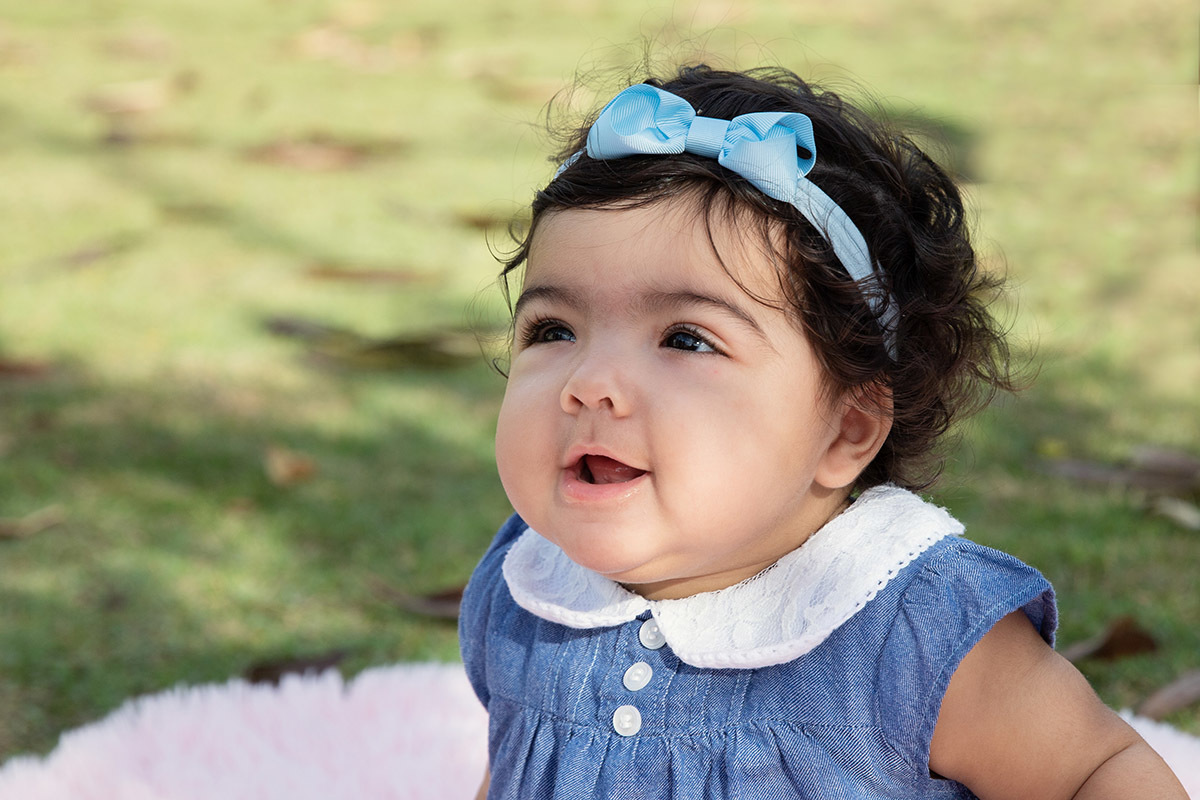 Ensaio de bebê: Ester sorrindo no jardim no Rio de Janeiro.