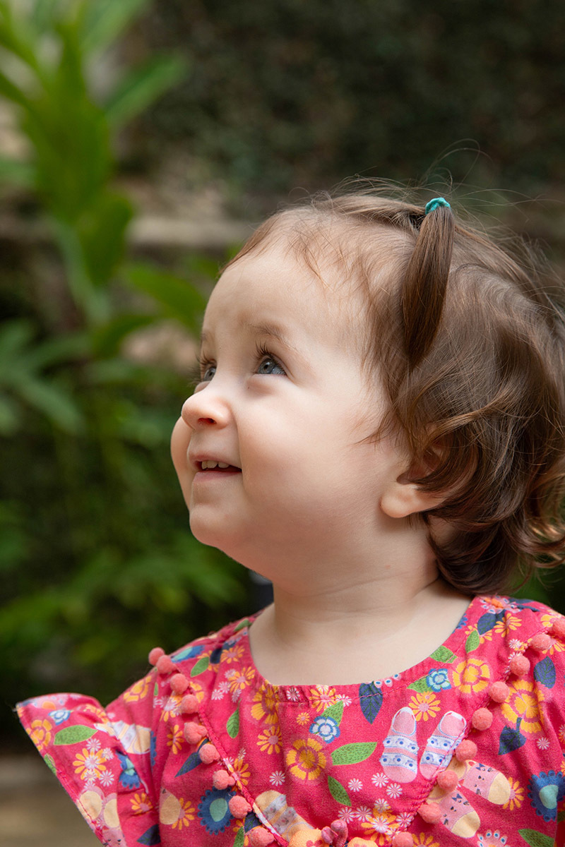 Ensaio de Família: Gaby sorrindo no jardim no Rio de Janeiro.