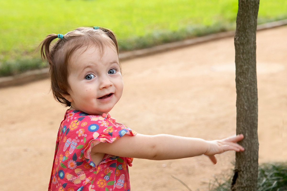 Ensaio de Família: Gaby sorrindo no jardim no Rio de Janeiro.