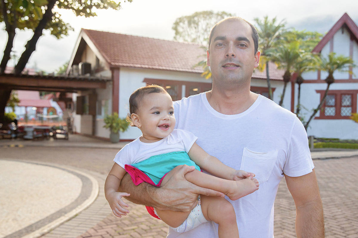 Ensaio de Família no Clube Piraquê: Laura no colo do pai, no Rio de Janeiro.