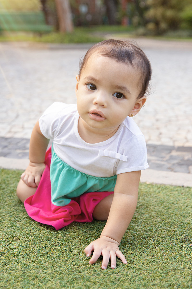 Ensaio de Família no Clube Piraquê: Laura brincando na grama, no Rio de Janeiro.