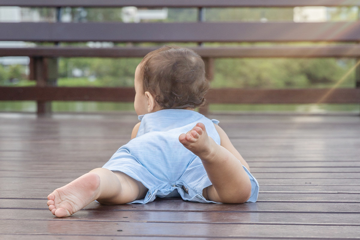 Ensaio de Família no Clube Piraquê: Laura deitada no deck de madeira, no Rio de Janeiro.