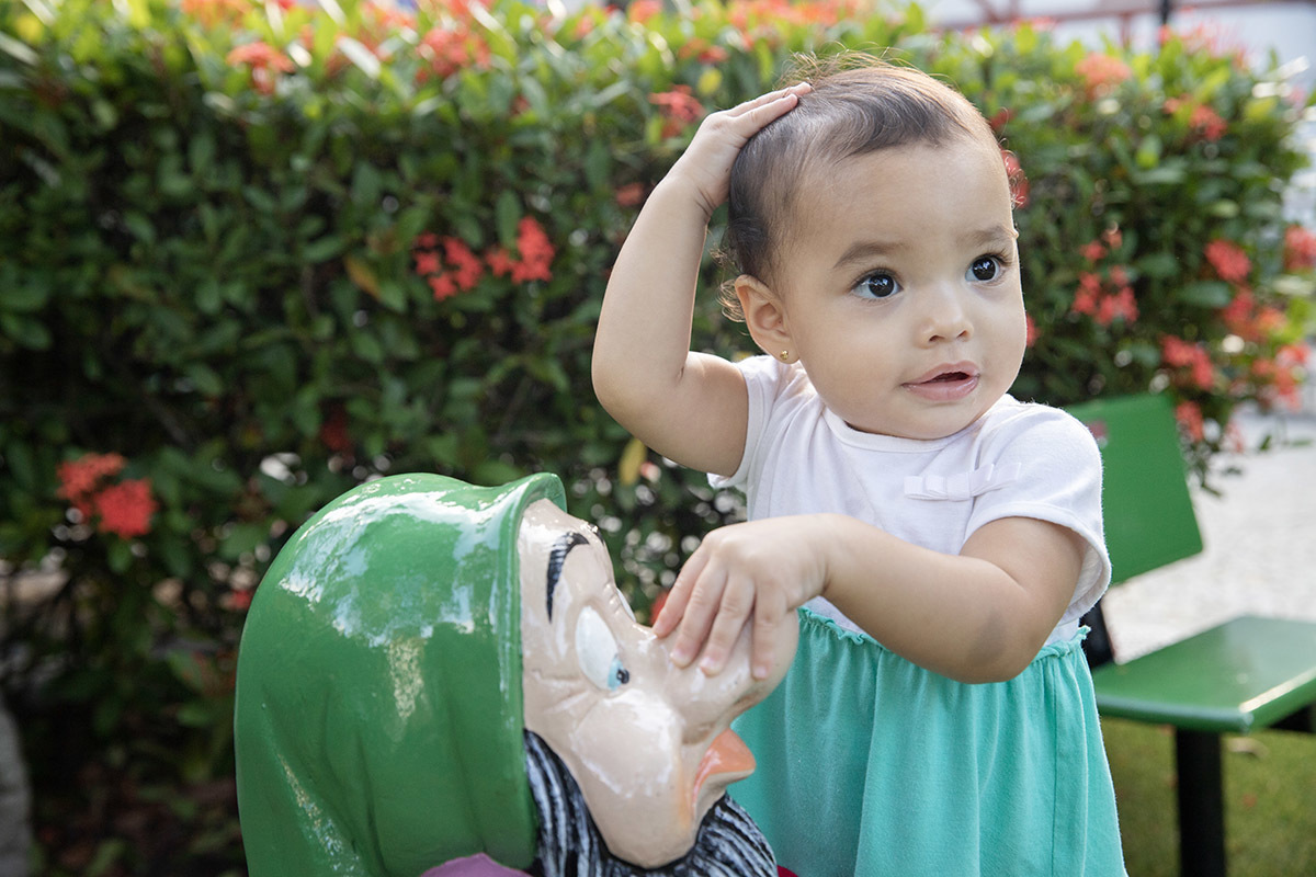 Ensaio de Família no Clube Piraquê: Laura brincando na grama, no Rio de Janeiro.