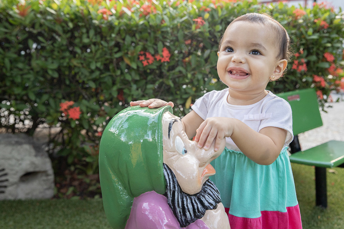 Ensaio de Família no Clube Piraquê: Laura brincando na grama, no Rio de Janeiro.