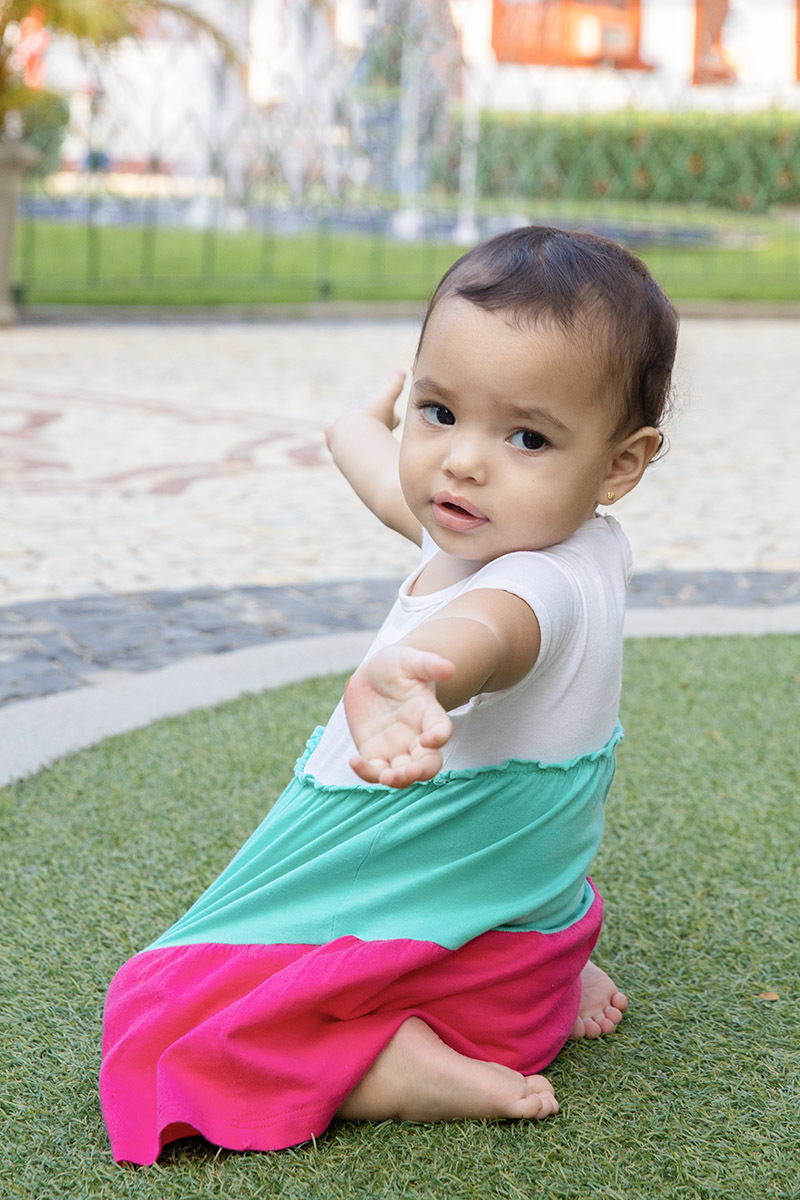 Ensaio de Família no Clube Piraquê: Laura brincando na grama, no Rio de Janeiro.