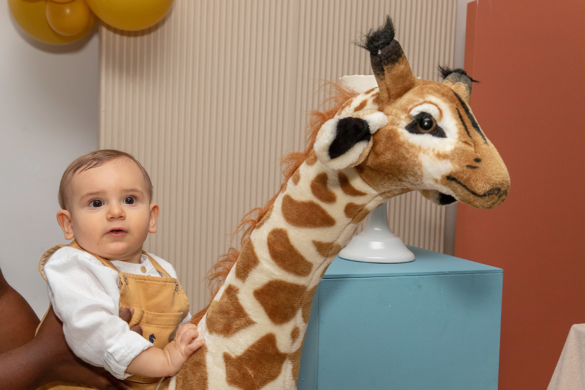 Festa de aniversário de 1 ano do Leonardo: Léo na girafa da decoração no Rio de Janeiro.