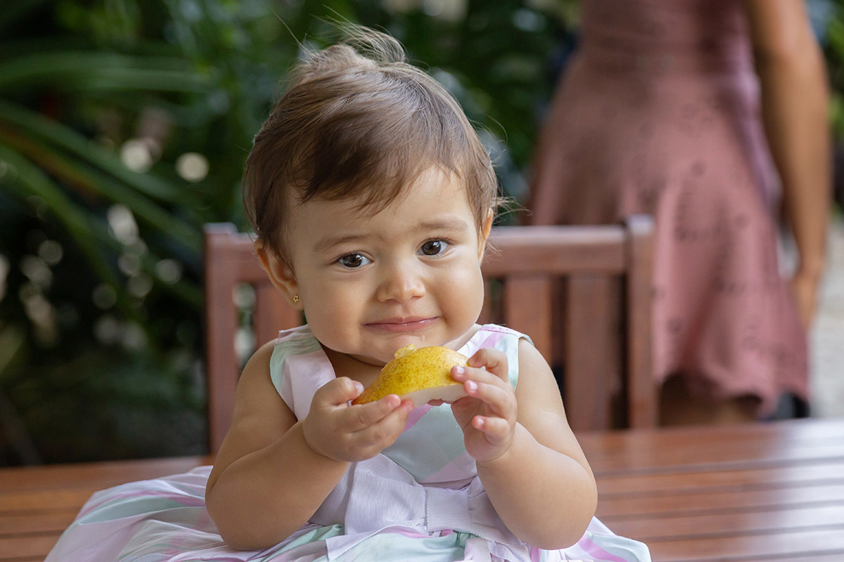 Festa de 1 ano da Maria Carolina: Maria Carolina segurando uma pera - RJ 