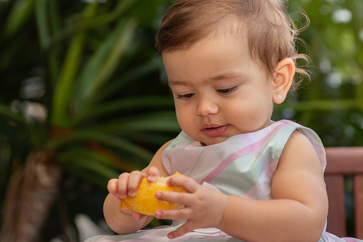Festa de 1 ano da Maria Carolina: Maria Carolina segurando uma pera - RJ 