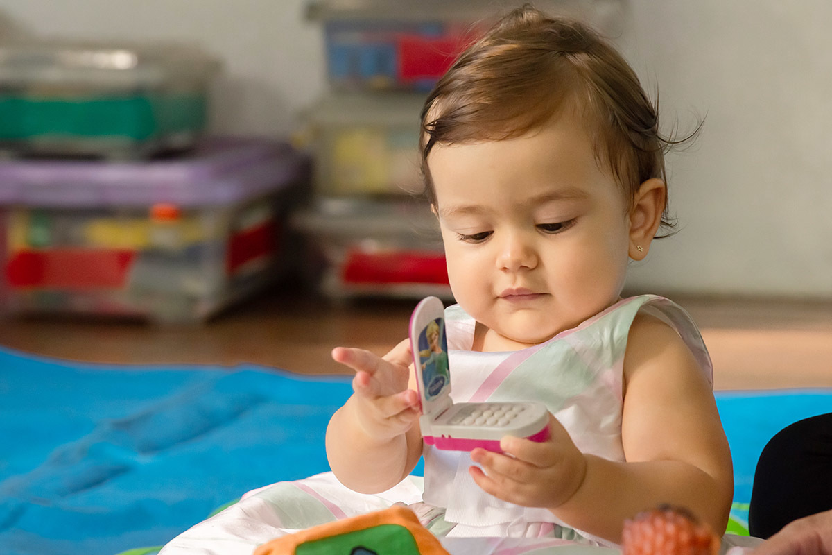 Festa de 1 ano da Maria Carolina: Maria Carolina brincando com um celular de brinquedo - RJ 