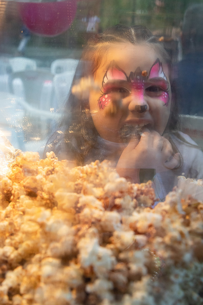 criança com o rosto pintado comendo pipoca na festa de aniversario - 6 anos - Rio de Janeiro - RJ.